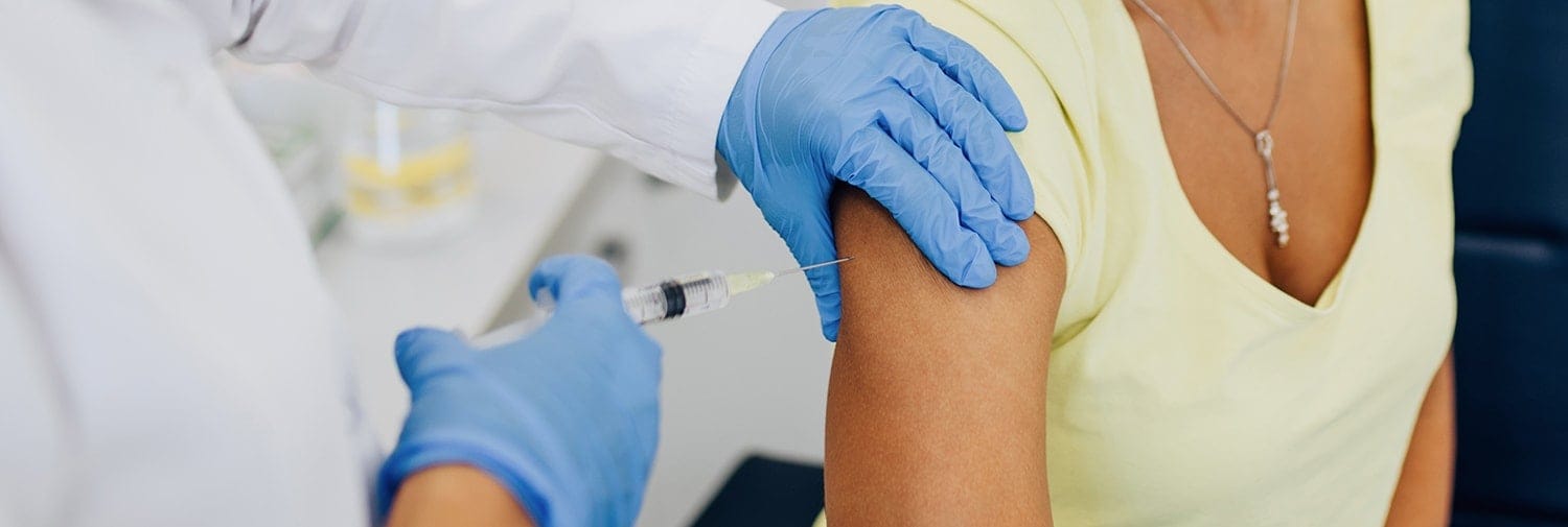 doctor injecting vaccine into woman's arm