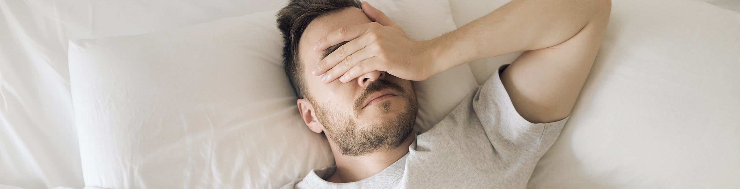 man hungover in bed