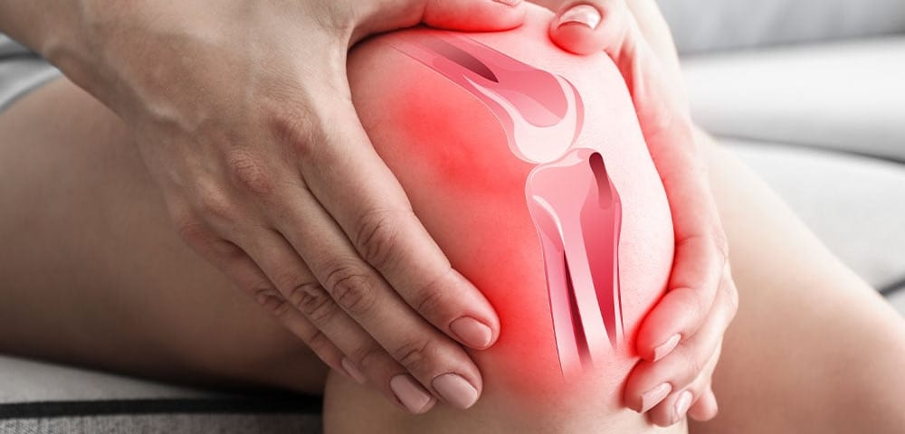 person gripping inflamed knee