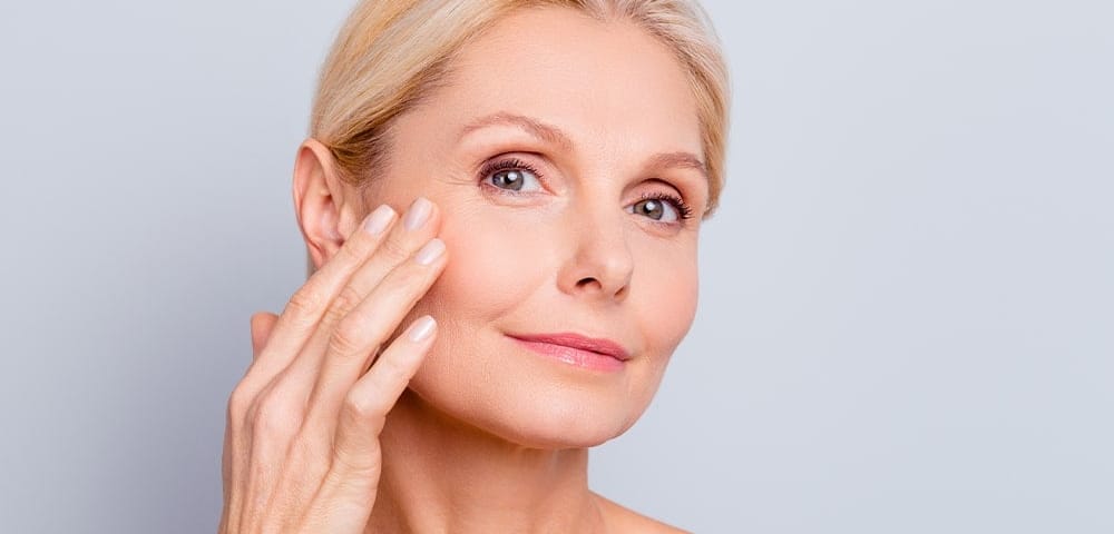 an older woman complete a skin care treatment for aging