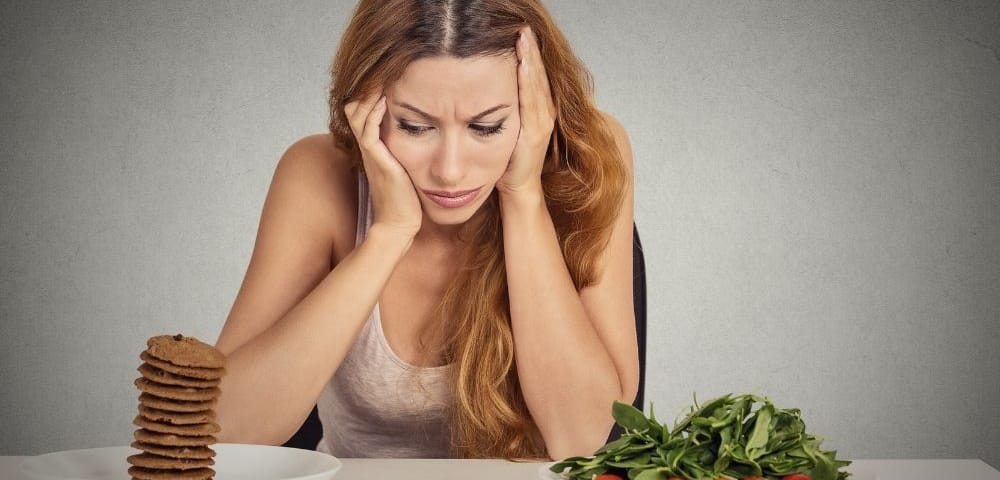 woman struggling with weight loss goals before learning how to control food cravings