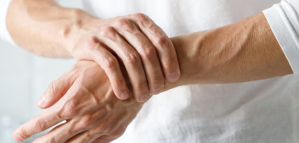 close up of woman dealing with chronic pain in her wrists