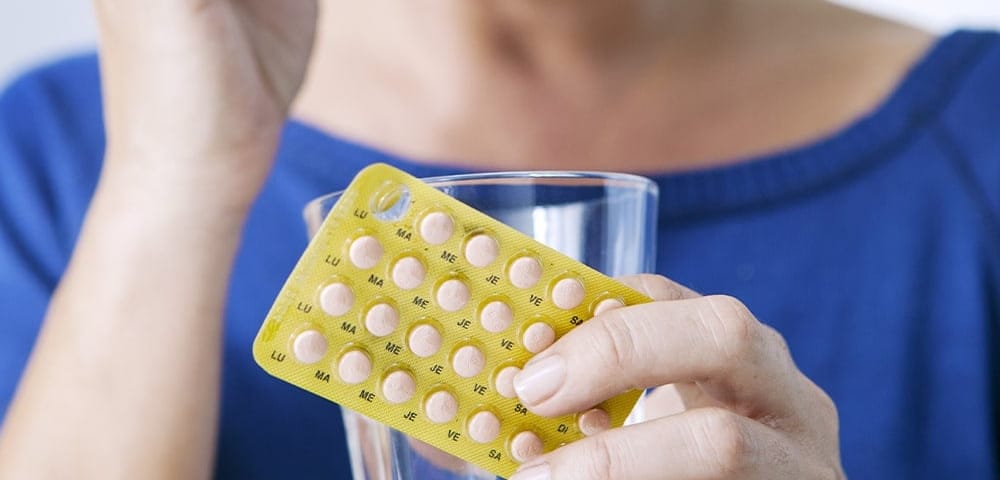 woman taking bioidentical hormone replacement therapy pills