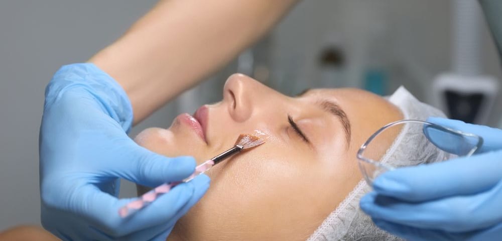 doctor applying chemical peel to woman's face