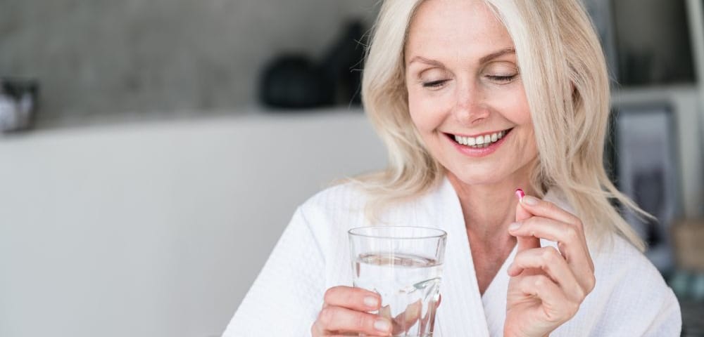 Woman taking a pill for hormone replacement therapy