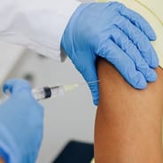 doctor injecting vaccine into woman's arm