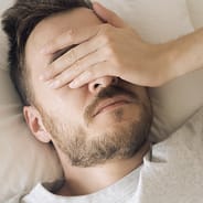 man hungover in bed