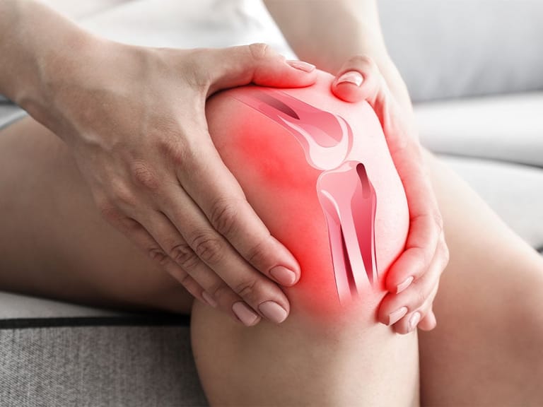 person gripping inflamed knee