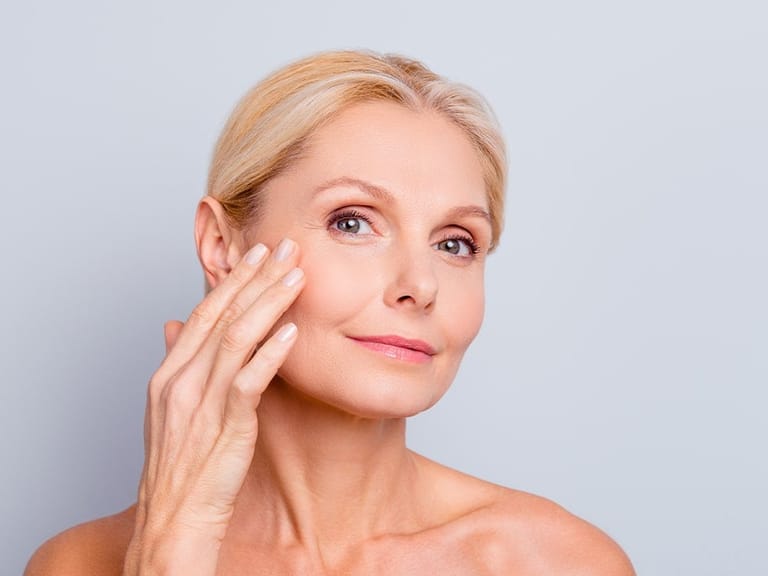 an older woman complete a skin care treatment for aging