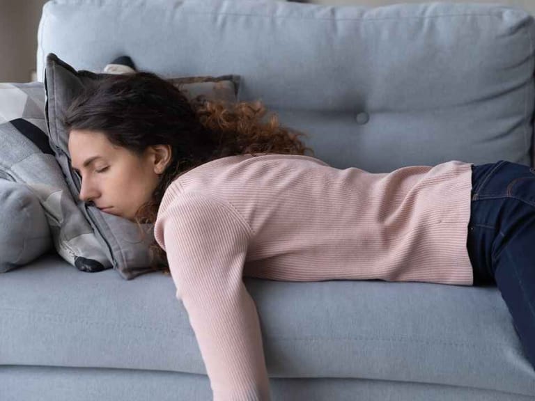 woman laying on couch displaying signs of low iron