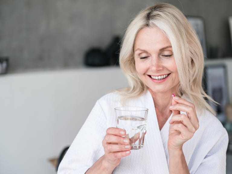 Woman taking a pill for hormone replacement therapy