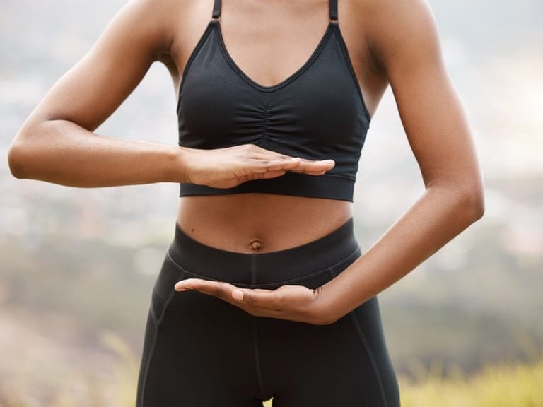 A women outside with her hands for gut health balance