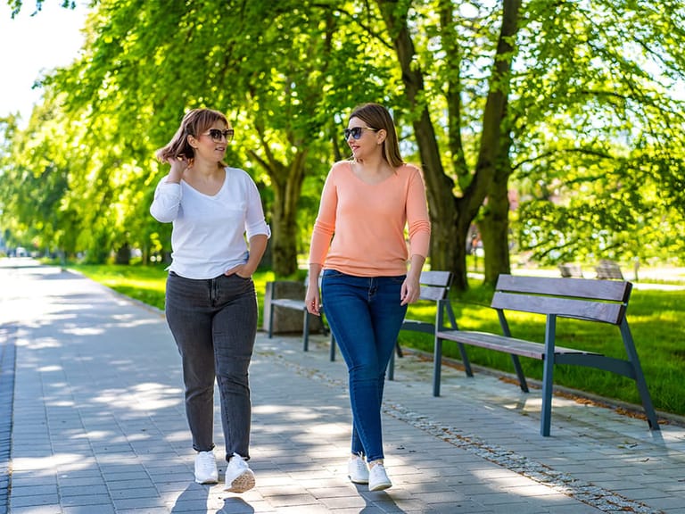 two women walking in a park