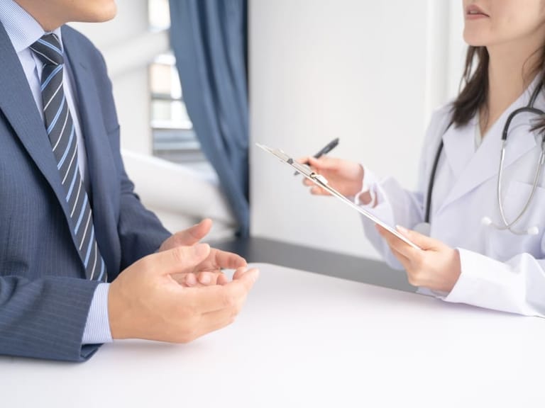 A female doctor talking to a male patient