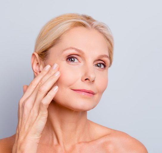 an older woman complete a skin care treatment for aging