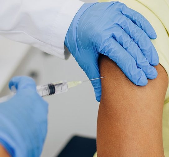 doctor injecting vaccine into woman's arm