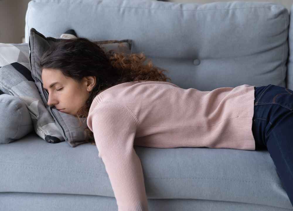 woman laying on couch displaying signs of low iron