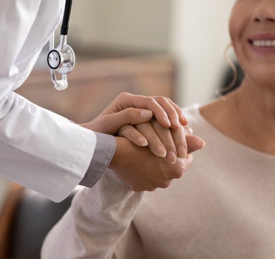close up of concierge doctor holding a smiling patient's hand