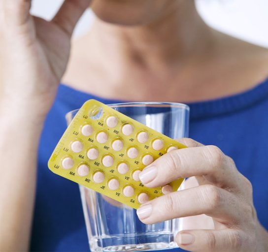 woman taking bioidentical hormone replacement therapy pills